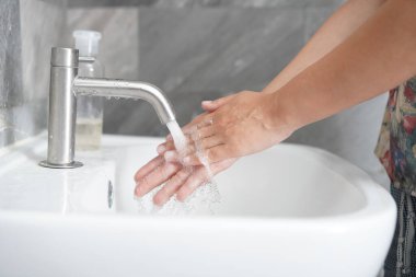 Coronavirus hastalığının önlenmesi için ellerini yıka. 2019 veya COVID-19. İnsanlar virüs enfeksiyonunu temizlemek için lavaboda ellerini yıkıyor..