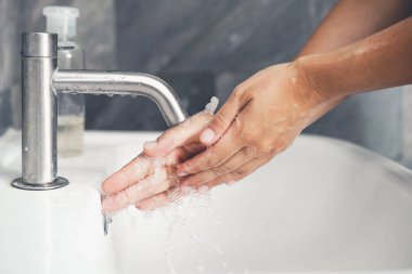 Coronavirus hastalığının önlenmesi için ellerini yıka. 2019 veya COVID-19. İnsanlar virüs enfeksiyonunu temizlemek için lavaboda ellerini yıkıyor..