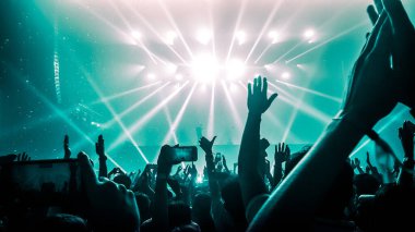Mutlu insanlar gece kulübü DJ parti konserinde dans eder ve sahnede DJ 'den elektronik dans müziği dinlerler. Siluet dolu neşeli kalabalık 2020 yılbaşı partisini kutluyor. İnsanların yaşam tarzı DJ gece hayatı.