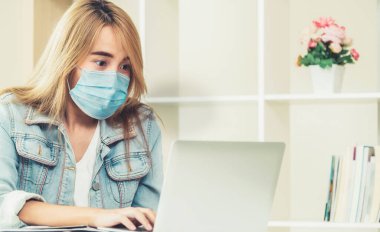 Evde yüz maskesi takan karantina altındaki kadın Coronavirus 'tan koruyor. Coronavirüs Hastalığı veya COVID-19 'un yayılmasını durdurmak için sosyal mesafeler kavramı.