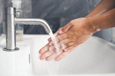 Coronavirus hastalığının önlenmesi için ellerini yıka. 2019 veya COVID-19. İnsanlar virüs enfeksiyonunu temizlemek için lavaboda ellerini yıkıyor..