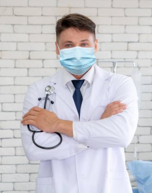 Doktor hastanede yüz maskesi takıyor. Coronavirus hastalığı ya da COVID-19 'dan korunuyor. Sağlık personeli, Coronavirus hastalığı veya COVID-19 enfeksiyonu kapan yüksek riskli kişilerdir..