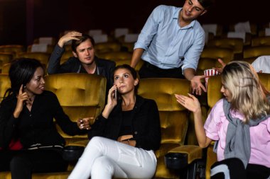 Sinema salonunda cep telefonuyla konuşan sinir bozucu kadın ona kızgın.