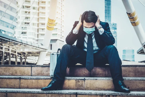 Unhappy sad business man with face mask protect from Coronavirus or Covid-19. Concept of unemployment problem caused by Coronavirus Covid-19.