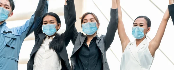 Confident business people with face mask protect from Coronavirus or COVID-19. Concept of help, support and collaboration together to overcome epidemic of Coronavirus or COVID-19 to reopen business.