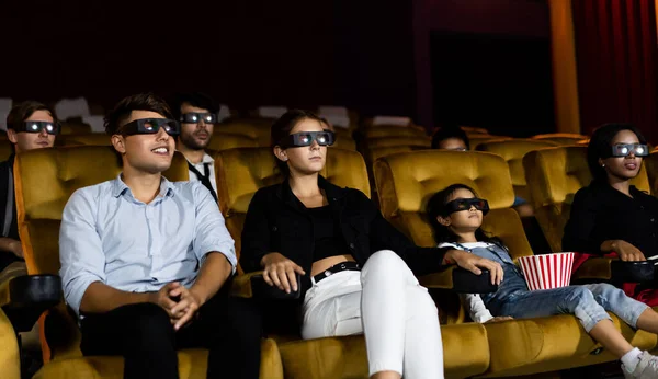 Group of people watch movie with 3D glasses in cinema theater with interest looking at the screen, exciting and enjoy