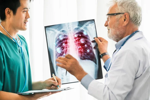 医師は X線フィルムに表示されているコロナウイルス病2019またはCovid 19を分析します このフィルムは コロナウイルスが肺および呼吸器に感染するシンボルを示しています 医療技術と医療の概念 — ストック写真