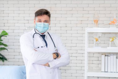 Doktor hastanede yüz maskesi takıyor. Coronavirus hastalığı ya da COVID-19 'dan korunuyor. Sağlık personeli, Coronavirus hastalığı veya COVID-19 enfeksiyonu kapan yüksek riskli kişilerdir..