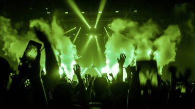 Mutlu insanlar gece kulübü DJ parti konserinde dans eder ve sahnede DJ 'den elektronik dans müziği dinlerler. Siluet dolu neşeli kalabalık 2020 yılbaşı partisini kutluyor. İnsanların yaşam tarzı DJ gece hayatı.