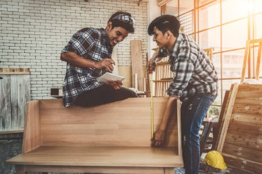 Marangoz atölyede ahşap işçiliği yapıyor. İnşaat malzemesi ya da ahşap mobilya üretiyor. Genç Asyalı marangoz zanaat için profesyonel araçlar kullanır. DIY üreticisi ve marangozluk konsepti.