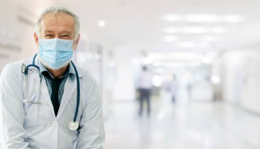 Doktor hastanede yüz maskesi takıyor. Coronavirus hastalığı ya da COVID-19 'dan korunuyor. Sağlık personeli, Coronavirus hastalığı veya COVID-19 enfeksiyonu kapan yüksek riskli kişilerdir..