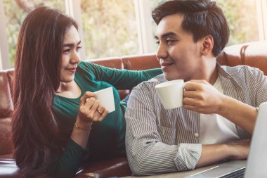Mutlu Asyalı çift evde kahve içer. Aşk ilişkisi ve yaşam tarzı kavramı.