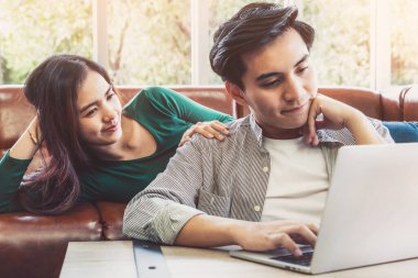 Genç çift evdeki internet sitesinden online alışveriş için kredi kartını kullanıyor. Kredi kartındaki numara sahte. Kredi kartında kişisel bilgi yok. Çevrimiçi iş alışveriş kavramı.