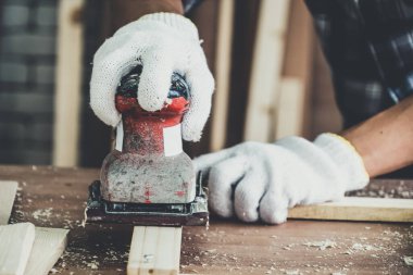 Marangoz atölyede ahşap işçiliği yapıyor. İnşaat malzemesi ya da ahşap mobilya üretiyor. Genç Asyalı marangoz zanaat için profesyonel araçlar kullanır. DIY üreticisi ve marangozluk konsepti.