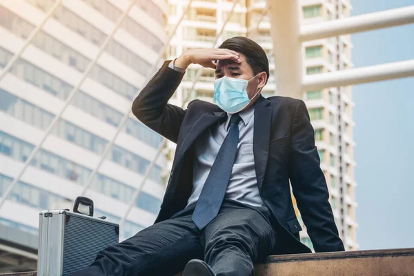Unhappy sad business man with face mask protect from Coronavirus or Covid-19. Concept of unemployment problem caused by Coronavirus Covid-19.