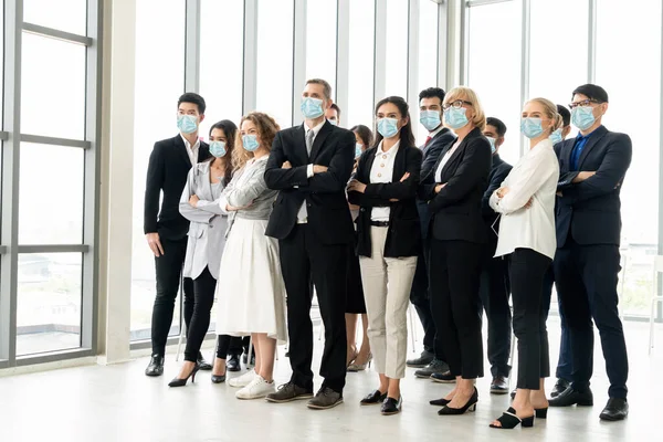 Confident business people with face mask protect from Coronavirus or COVID-19. Concept of help, support and collaboration together to overcome epidemic of Coronavirus or COVID-19 to reopen business.