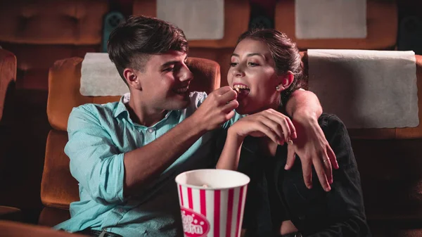 男性と女性は食べているとポップコーンを投げることは楽しかったです彼らの口に劇場 — ストック写真