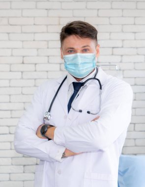 Doktor hastanede yüz maskesi takıyor. Coronavirus hastalığı ya da COVID-19 'dan korunuyor. Sağlık personeli, Coronavirus hastalığı veya COVID-19 enfeksiyonu kapan yüksek riskli kişilerdir..