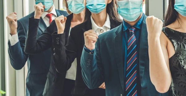 Confident business people with face mask protect from Coronavirus or COVID-19. Concept of help, support and collaboration together to overcome epidemic of Coronavirus or COVID-19 to reopen business.