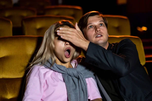 一对在电影院看惊悚电影的夫妇 男人们用双手合上女友的眼睛 — 图库照片